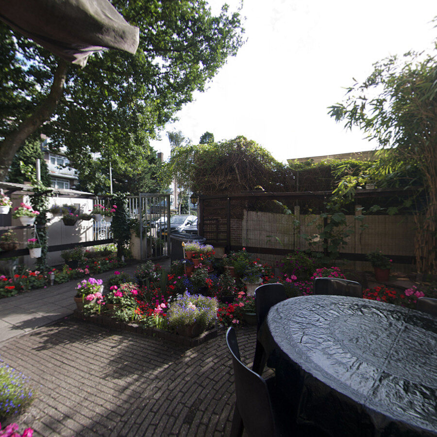 De tuin met tafels, bamboe en bloemen